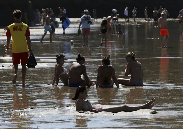 People enjoy the sea at Biarritz beach, southwestern France, southwestern France, Friday, Aug.3, 2018. The hot weather is expected to last for several days across the country. (Photo by Bob Edme/AP Photo)