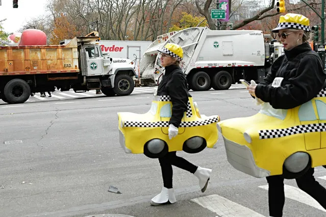 People in Customs arrive to the 90th annual Macy's Thanksgiving Day Parade as dump trucks block the streets on November 24, 2016 in New York. (Photo by Kena Betancur/AFP Photo)