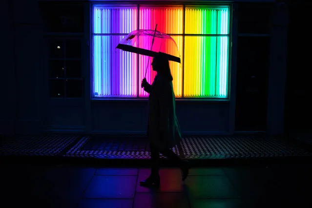 A member of the public walks past the outdoor neon art installation entitled Wavelength in Two Parts, created by artists Rob & Nick in London, England on October 20, 2020. (Photo by David Parry/PA Wire Press Association)
