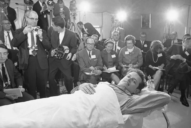 Sen. Edward M. Kennedy smiles happily as he held a press conference at New England Baptist Hospital in Boston October 19, 1964. Sen. Kennedy described the plane crash in which his back was broken four months ago today while strapped in the orthopedic frame to which he has been confined since the accident. The pilot of the plane and a Kennedy aide were killed in the June 19 accident in Western Massachusetts. (Photo by AP Photo)