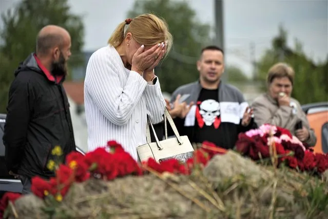 A woman reacts at an informal memorial next to the former “PMC Wagner Centre” in St. Petersburg, Russia, Thursday, August 24, 2023. Russian mercenary leader Yevgeny Prigozhin, the founder of the Wagner Group, reportedly died when a private jet he was said to be on crashed on Aug. 23, 2023, killing all 10 people on board. (Photo by Dmitri Lovetsky/AP Photo)