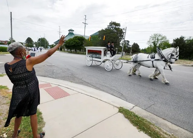 A woman waves towards the casket of Andrew Brown Jr. as it is carried by a horse-drawn carriage during his funeral procession in Elizabeth City, North Carolina, U.S. May 3, 2021. (Photo by Jonathan Drake/Reuters)