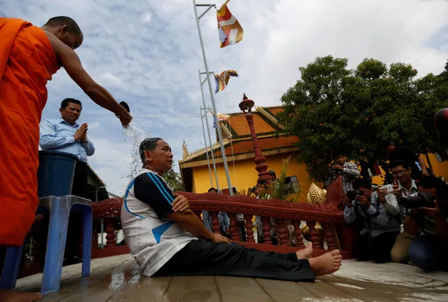 A Buddhist monk pours water on a member of the Cambodia National Rescue Party (CNRP), who was released from prison on Thursday after a royal pardon, at a pagoda on the outskirts of Phnom Penh, Cambodia December 8, 2016. (Photo by Samrang Pring/Reuters)