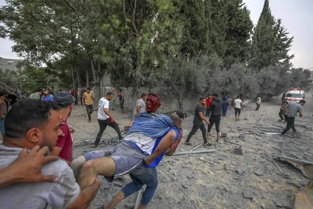Palestinians evacuate a man wounded during an Israeli aerial bombardment of Jabaliya, near Gaza City, Wednesday, October 11, 2023. (Photo by Mohammad Al Masri/AP Photo)