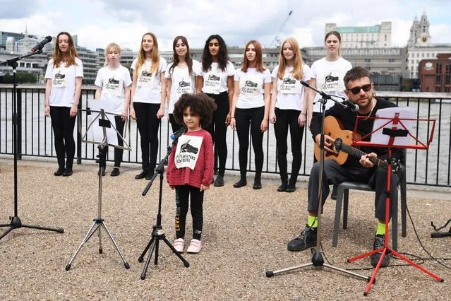 English musician Damon Albarn (R) participates in the launch of environmental activists Extinction Rebellion Writers Rebel’s “Paint the Land” project, on the banks of the river Thames in central London on June 25, 2021. (Photo by Daniel Leal-Olivas/AFP Photo)