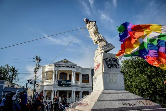 Protestors topple a statue of Christopher Columbus during a demonstration against government in Barranquilla, Colombia on June 28, 2021. (Photo by Mery Granados/Reuters)