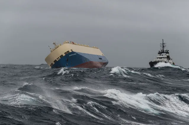 In this photo taken on Sunday, January 31, 2016 and provided by the Prefecture Maritime Atlantique, the cargo ship “Moderm Express” is pictured drifting off the coast of France. The cargo ship listing in the water is drifting empty off the coast of France, as maritime rescue workers wait for the seas to calm. The captain of the capsized Modern Express, sailing with a load of wood in the Bay of Biscay, 300 kilometers (180 miles) off the coast of France, sent out a distress call on Tuesday and its crew of 22 was evacuated by Spanish helicopters. (Photo by Loic Bernardin/ Prefecture Maritime Atlantique via AP Photo)