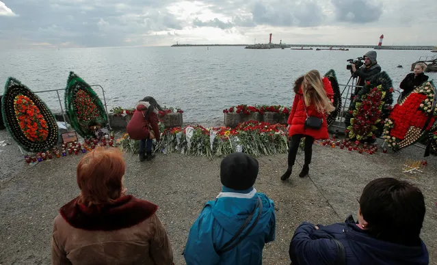 People lay flowers in memory of passengers and crew members of Russian military Tu-154, which crashed into the Black Sea on its way to Syria on Sunday, at an embankment in the Black Sea resort city of Sochi, Russia, December 26, 2016. (Photo by Maxim Shemetov/Reuters)