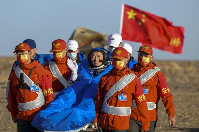 In this photo released by Xinhua News Agency, astronaut Gui Haichao waves as he is carried out of the re-entry capsule of the Shenzhou-14 manned space mission after it landed successfully at the Dongfeng landing site in northern China's Inner Mongolia Autonomous Region, Tuesday, October 31, 2023. The previous crew of China's orbiting space station returned to earth Tuesday morning, all reportedly in good health, amid a sharpening rivalry with the U.S. over space exploration and plans to put astronauts on the moon before 2030. (Photo by Li Zhipeng/Xinhua via AP Photo)