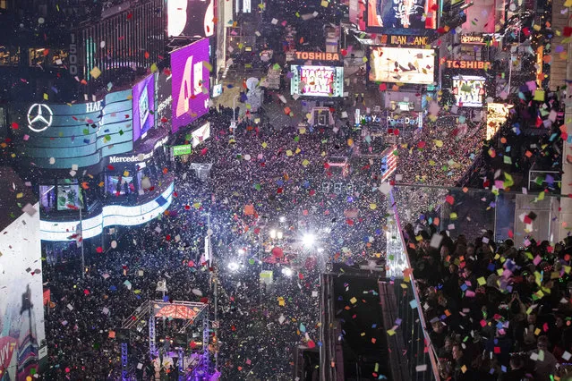 Revelers celebrate the new year as confetti flies over New York's Times Square as seen from the Marriott Marquis, Sunday, January 1, 2017. (Photo by Mary Altaffer/AP Photo)