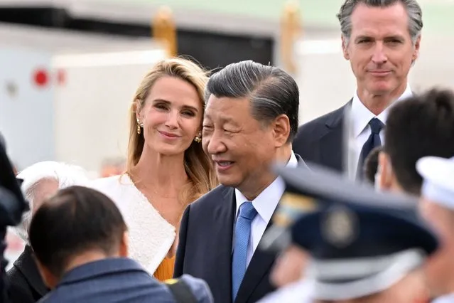 California Governor Gavin Newsom (R) and his partner Jennifer Siebel Newsom (L) look on as Chinese President Xi Jinping (C) arrives at San Francisco International airport, as to attend the Asia-Pacific Economic Cooperation (APEC) leaders' week in San Francisco, California, on November 14, 2023. Xi arrived in San Francisco on November 14, 2023, a day ahead of his highly anticipated meeting with American counterpart Joe Biden. Xi last traveled to the United States six years ago, and is due for lengthy talks with Biden in their first in-person meeting in a year. (Photo by Frederic J. Brown/AFP Photo)