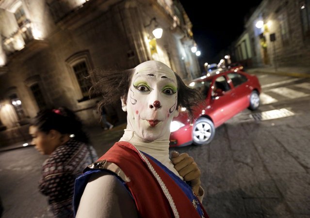 A clown perfoms on the street near the Cathedral, ahead of Pope Francis' visit to Morelia in the Mexican state of Michoacan February 15, 2016. (Photo by Henry Romero/Reuters)