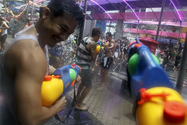 Revelers use water guns as they participate in a water fight during Songkran Festival celebrations at Silom road in Bangkok April 12, 2015. (Photo by Athit Perawongmetha/Reuters)