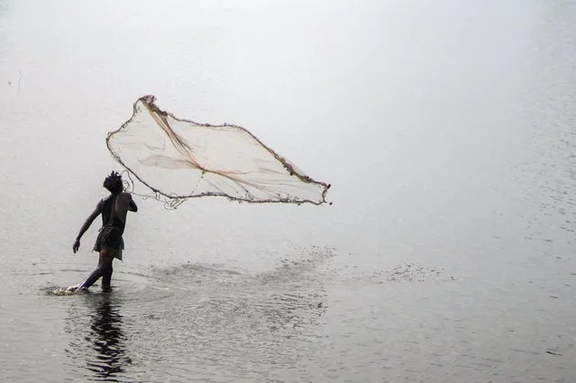 A fisherman casts his net in a lake on the outskirts of Muanda, western Democratic Republic of Congo, Saturday, December 23, 2023. (Photo by Mosa'ab Elshamy/AP Photo)