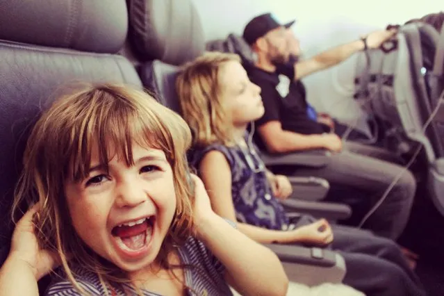 Little kid makes funny faces on an airplane. (Photo by Lisa5201/Getty Images)