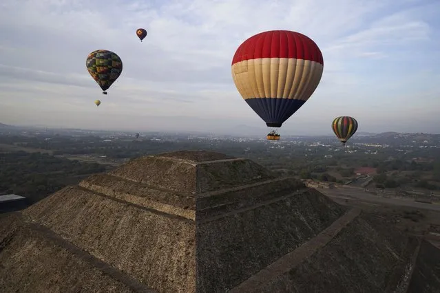 Tourists ride in hot air balloons flying over the Sun pyramid at the Teotihuacan archaeological site, just north of Mexico City, December 24, 2023. (Photo by Marco Ugarte/AP Photo)