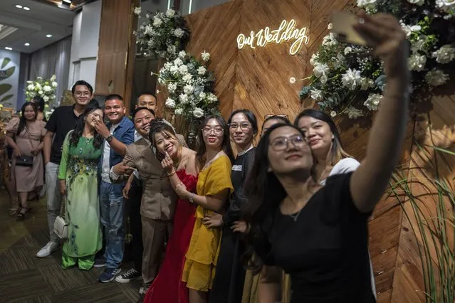 A bride and groom take a group picture with their guests after a wedding ceremony in Ho Chi Minh City, Vietnam, January 14, 2024. (Photo by Jae C. Hong/AP Photo)