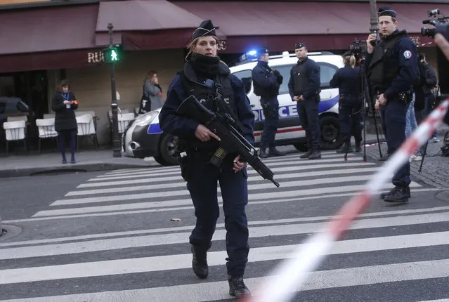 Police officers take position outside the Louvre museum in Paris,Friday, February 3, 2017. Paris police say a soldier has opened fire outside the Louvre Museum after he was attacked by someone, and the area is being evacuated. (Photo by Thibault Camus/AP Photo)