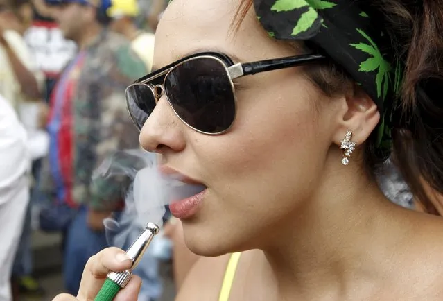 A woman smokes marijuana during a demonstration in support of the legalization of marijuana in Medellin, May 2, 2015. (Photo by Fredy Builes/Reuters)