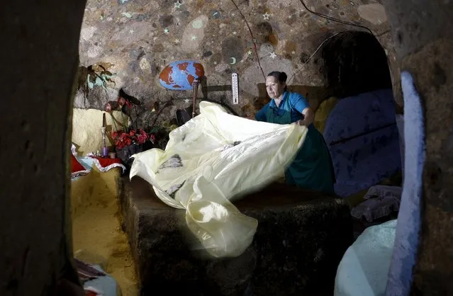 Cristal Barrantes makes a bed in her bedroom at the house that her husband Manuel Barrantes built underground in San Isidro de Perez Zeledon, Costa Rica, March 14, 2016. (Photo by Juan Carlos Ulate/Reuters)