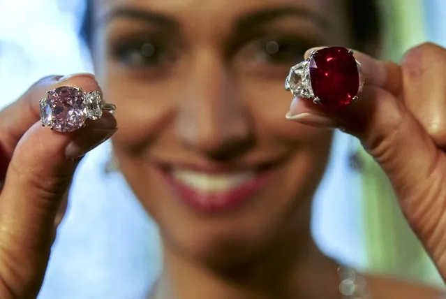 A model holds the “Sunrise Ruby” (R) a Burmese ruby weighing 25.59 carats, and the “Historic Pink Diamond”, a Fancy Vivid diamond weighing 8.72 carats during an auction preview at Sotheby's auction house in Geneva, Switzerland, May 6, 2015. The ruby is expected to sell between US $ 12,000,000 to 18,000,000 and the diamond US $ 14,000,000 to 18,000,000  when they are auctioned on May 12 in Geneva. (Photo by Denis Balibouse/Reuters)