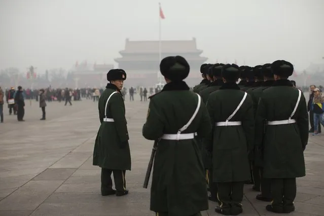 Paramilitary policemen stand ready to march across Tiananmen Square on a severely polluted day in Beijing, China, Tuesday, February 25, 2014. Pollution across a large swath of northern China worsened on Tuesday. (Photo by Alexander F. Yuan/AP Photo)
