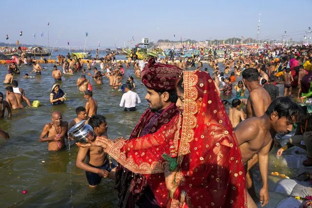 A newly married couple offer prayers as Hindu devotees take dip at the Sangam, the meeting point of the Ganges and the Yamuna rivers, during Shivaratri festival in Prayagraj, India, Friday, March 8, 2024. (Photo by Rajesh Kumar Singh/AP Photo)
