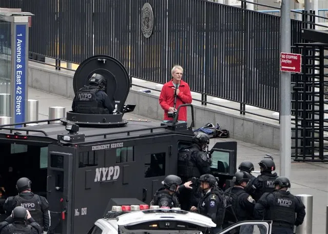 An armed man speaks with member of the NYPD outside the United Nations Headquarters in New York City, U.S., December 2, 2021. After three hours, the intense stand-off concluded as the unidentified man dropped the weapon and peacefully surrendered to police. NYPD officials confirmed the man had several papers he wanted to deliver to the UN. After surrendering, officials with the emergency services unit hand-delivered the documents to officials at the UN. (Photo by Carlo Allegri/Reuters)