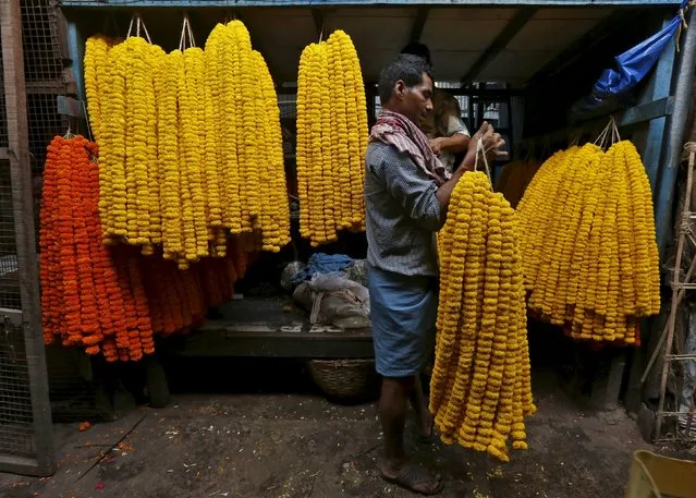 A man collects garlands of marigold flowers from a wholesale flower market for sale in Kolkata, India, April 7, 2016. (Photo by Rupak De Chowdhuri/Reuters)