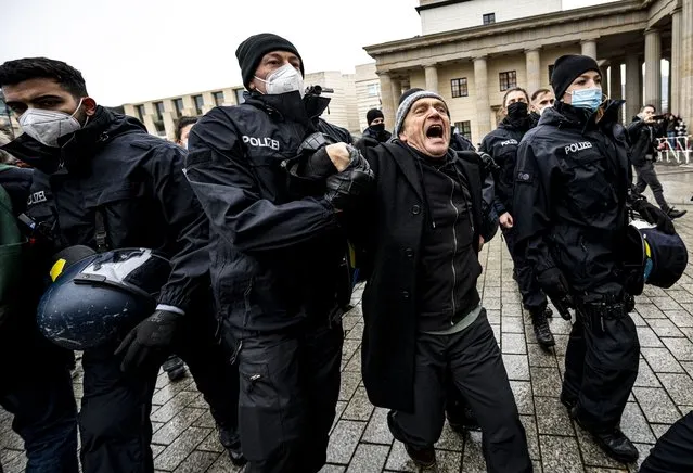 The Berlin police takes away a participant of the forbidden demonstration of opponents of Corona rules in Berlin, Germany, Saturday, December 18, 2021. The demonstration had been banned by the Berlin police. (Photo by Fabian Sommer/dpa via AP Photo)