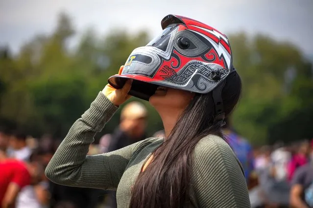 A woman observes the Annular Solar Eclipse at the facilities of the National Autonomous University of Mexico (UNAM) in Mexico City, Mexico on October 14, 2023. (Photo by Daniel Cardenas/Anadolu via Getty Images)