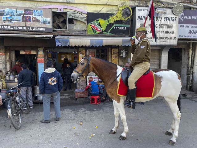 A policeman patrolling on horse back in the morning takes a tea break in Lucknow, India, Wednesday, January12, 2022. (Photo by Rajesh Kumar Singh/AP Photo)