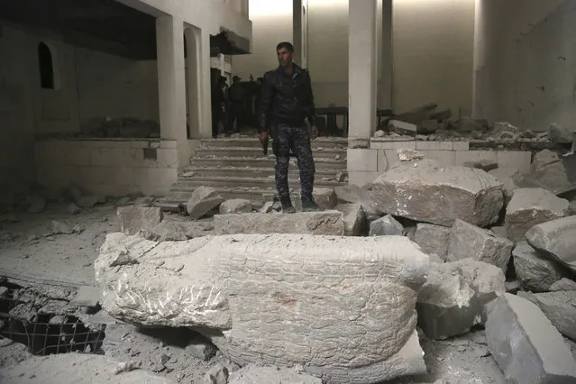 Iraqi federal police inspect the inside of Mosul's heavily damaged museum. Most of the artifacts inside the building appeared to be completely destroyed. The basement level that was the museum's library had been burned. The floors were covered in the ashes of ancient manuscripts, in western Mosul, Iraq, Wednesday, March 8, 2017. (Photo by Khalid Mohammed/AP Photo)