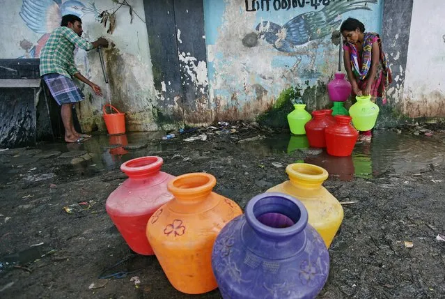 Residents fill their empty containers with water from a municipal tap in Chennai, June 28, 2019. (Photo by P. Ravikumar/Reuters)