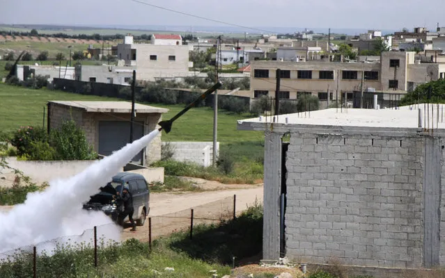 Fighters from the Tawhid Brigade, which operates under the “Free Syrian Army”, launch a locally made rocket towards forces loyal to President Bashar al-Assad in Muhrada, Hama province April 10, 2014. (Photo by Ahmad Rif/Reuters)