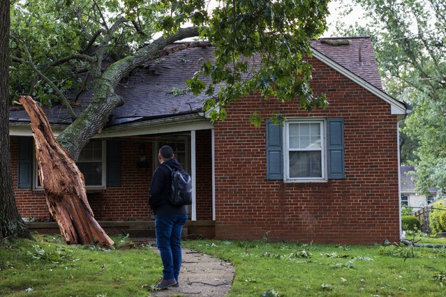 A person observes a home that was hit by a fallen tree in Gaithersburg, Maryland after a tornado moved through the area the previous evening, on June 6, 2024. (Photo by Tom Brenner for The Washington Post)