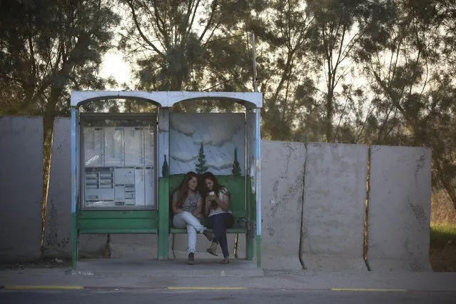 In this Tuesday, June 30, 2015. photo, Israeli girls wait for transportation in a bus stop protected with concrete blocks near the southern Israeli town of Sderot, next to the Israel-Gaza border. (Photo by Oded Balilty/AP Photo)
