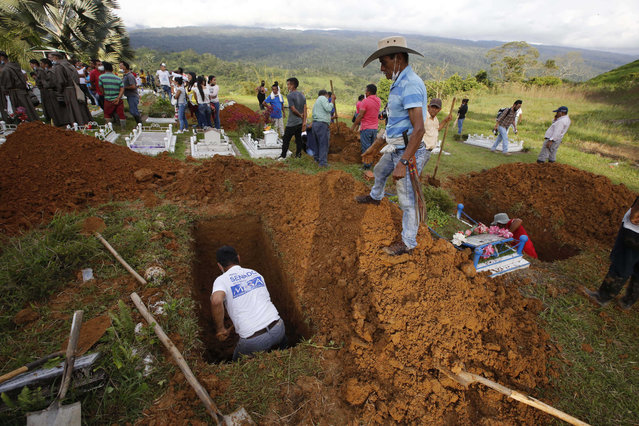 Men dig a grave during a mass burial for victims of a deadly avalanche in Mocoa, Colombia, Monday, April 3, 2017. The grim search continues for the missing in southern Colombia after surging rivers sent an avalanche of floodwaters, mud and debris through the small city, killing more than 260 people and leaving many more injured and homeless. (Photo by Fernando Vergara/AP Photo)