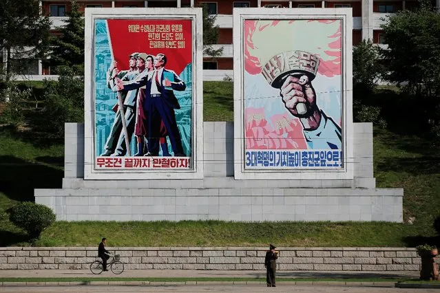 People pass in front of large posters placed in central Pyongyang, North Korea May 4, 2016. (Photo by Damir Sagolj/Reuters)