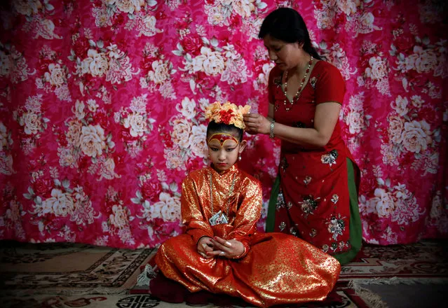 Living Goddess Kumari Unikia Bajracharya is adorned by her mother before taking part in the Chariot Festival of Rato Machhindranath in Lalitpur, Nepal May 10, 2016. Rato Machhindranath is known as the god of rain and both Hindus and Buddhists worship Machhindranath for good rain to prevent drought during the rice harvest season. (Photo by Navesh Chitrakar/Reuters)