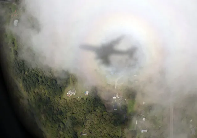 The shadow of Air Force One, with President Barack Obama aboard, is seen on a cloud as it approaches Paine Field Airport, Tuesday, April 22, 2014, in Everett, Wash., en route to Oso, Wash., the site of the deadly mudslide that struck the community in March. (Photo by Carolyn Kaster/AP Photo)