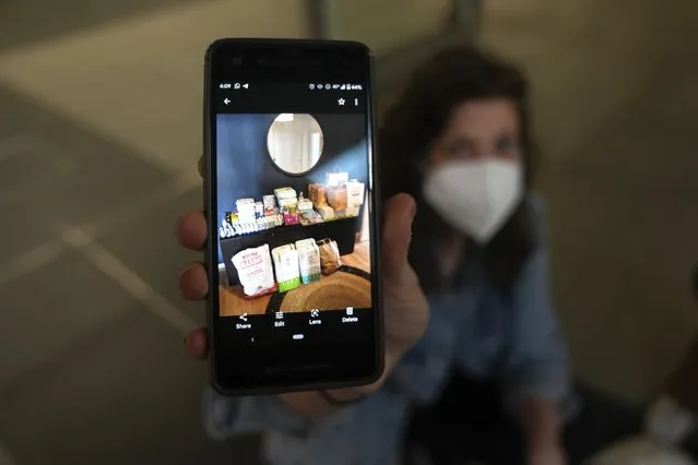 Alyse Conn-Powers shows a photo of relief goods bought for refugees from the Ukraine, at the main train station in Berlin, Germany, Tuesday, March 15, 2022. They have come to the train station every other day to drop off supplies they've bought with donations raised back home in the U.S. (Photo by Markus Schreiber/AP Photo)