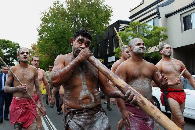 A indigenous man plays a didgeridoo as he leads the ANZAC march towards Redfern Park on April 25, 2017 in Sydney, Australia. The annual ANZAC coloured diggers event and march brings together the Indigenous and non-Indigenous community to celebrate the contributions of Aboriginal and Torres Strait Islander servicemen and servicewomen. (Photo by Lisa Maree Williams/Getty Images)