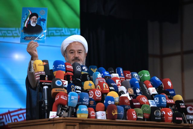 Iranian cleric Ahmad Akbari shows a portrait of the late President Ebrahim Raisi, who was killed in a helicopter crash in May, at the conclusion of a press briefing after registering his name as candidate for the June 28 presidential election at the Interior Ministry, in Tehran, Iran, Monday, June 3, 2024. All candidates must be approved by Iran's 12-member Guardian Council, a panel of clerics and jurists ultimately overseen by the Supreme Leader Ayatollah Ali Khamenei. (Photo by Vahid Salemi/AP Photo)