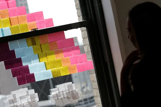 An employee creates a rainbow image on a window with Post-it notes at the Horizon Media offices at 75 Varick Street in lower Manhattan, New York, U.S., May 18, 2016. (Photo by Mike Segar/Reuters)
