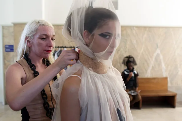 South African designer Suzaan Heyns makes final adjustments on an outfit worn by a model moments before her show at the MODAAFRICA, African fashion week in Lisbon, Sunday, July 19 2015. (Photo by Armando Franca/AP Photo)