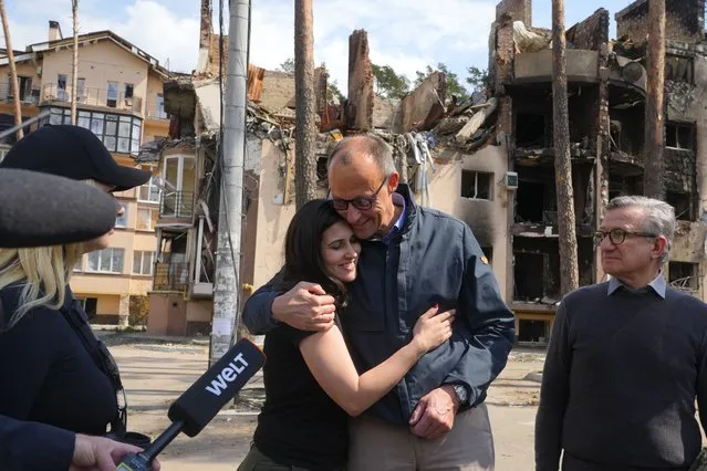 The Chairman of the German Christian Democratic Party (CDU) Friedrich Merz, center right, hugs with Halyna Yanchenko, a member of the Servant of the People political party, in Irpin, Ukraine, Tuesday, May 3, 2022. (Photo by Efrem Lukatsky/AP Photo)