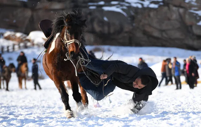 A residents performs equestrian skill at the second Sawur cultural tourism festival on animal husbandry in winter in Jeminay County, northwest China's Xinjiang Uygur Autonomous Region, December 29, 2019. (Photo by Song Yanhua/Xinhua News Agency/Barcroft Media)