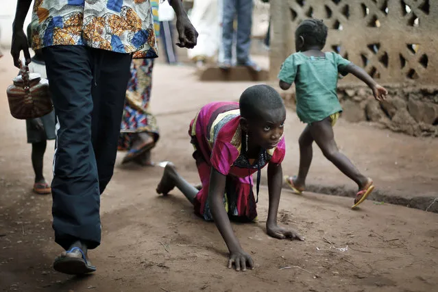 In this April 14, 2014 photo, Hamamatou Harouna, 10, crawls to the restroom on the grounds of the Catholic Church where she and hundreds of others found refuge in Carnot, Central African Republic. Human Rights Watch says people with disabilities in Central African Republic are at high risk during attacks and forced displacement, facing neglect in an ongoing humanitarian crisis. (Photo by Jerome Delay/AP Photo)