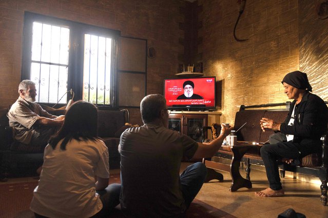 People attend a televised speech by the leader of the Hezbollah movement Hassan Nasrallah inside a house in the southern Lebanese village of Zawatar on September 19, 2024. Lebanon's powerful Hezbollah chief said on September 19 that Israel will not be able to return residents of the north displaced by 11 months of cross-border exchanges to their homes through military escalation. (Photo by Ammar Ammar/AFP Photo)